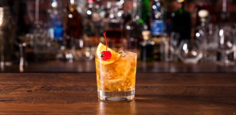 An old fashioned cocktail on a bar top.