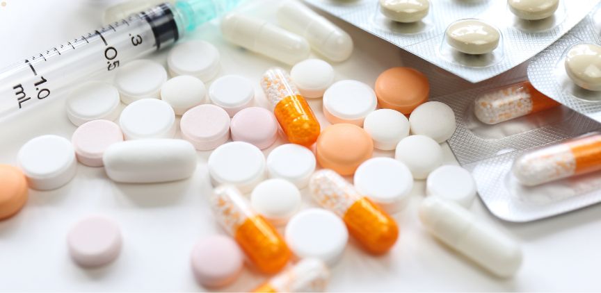 White and orange pills on a white table.