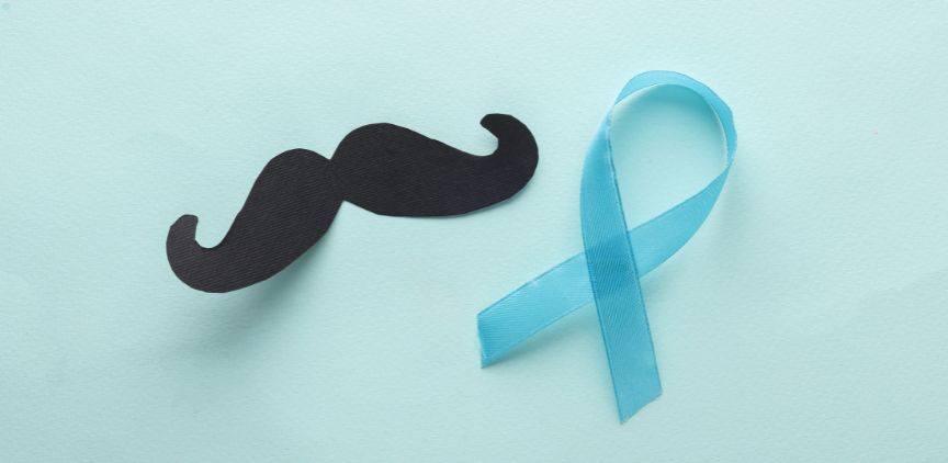 A black moustache and blue ribbon on a teal background.