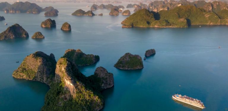 A cruise ship sailing past small islands in Asia.